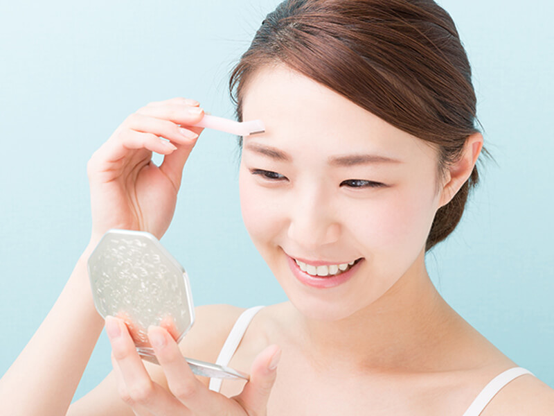 顔の産毛を自己処理している様子